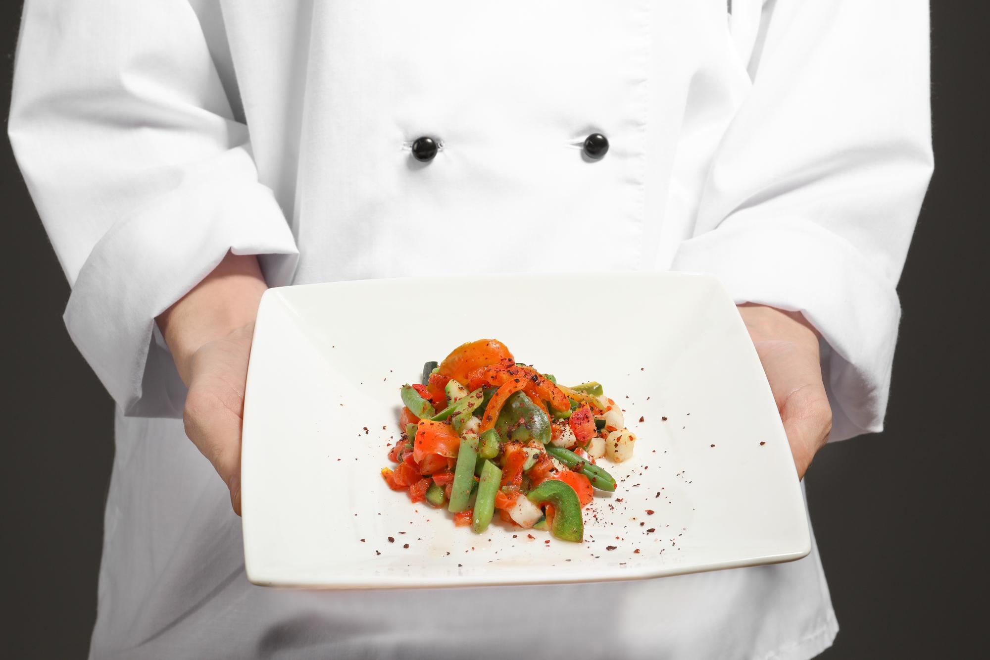 Chef che mostra una preparazione in cucina moderna